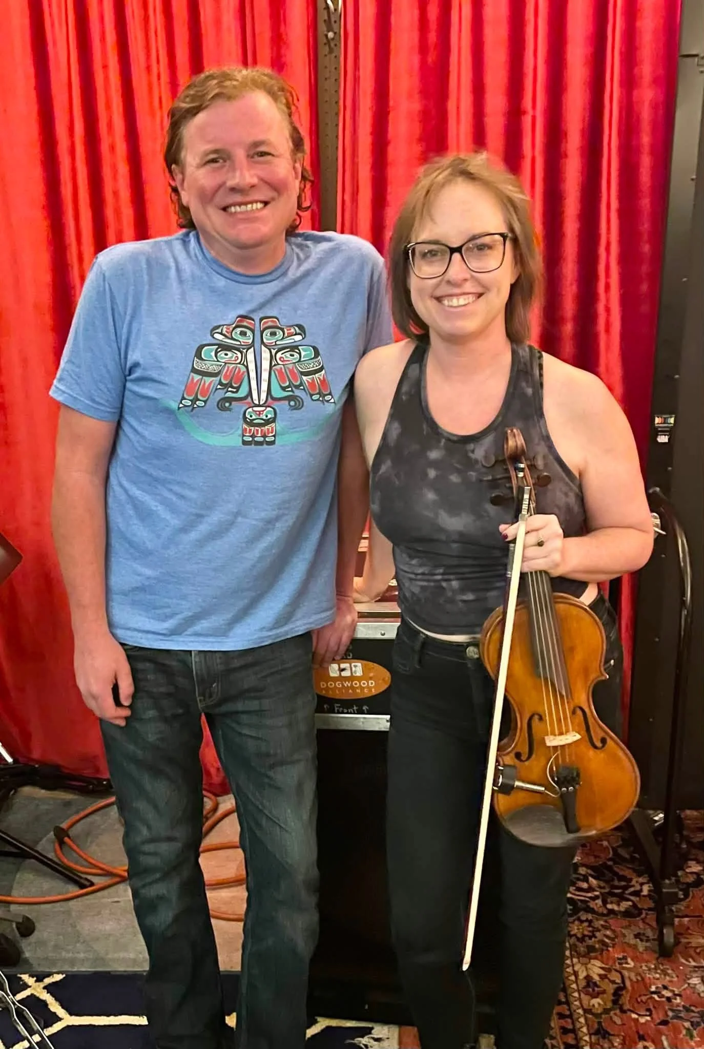 Jamie Dose with a fellow musician holding a fiddle